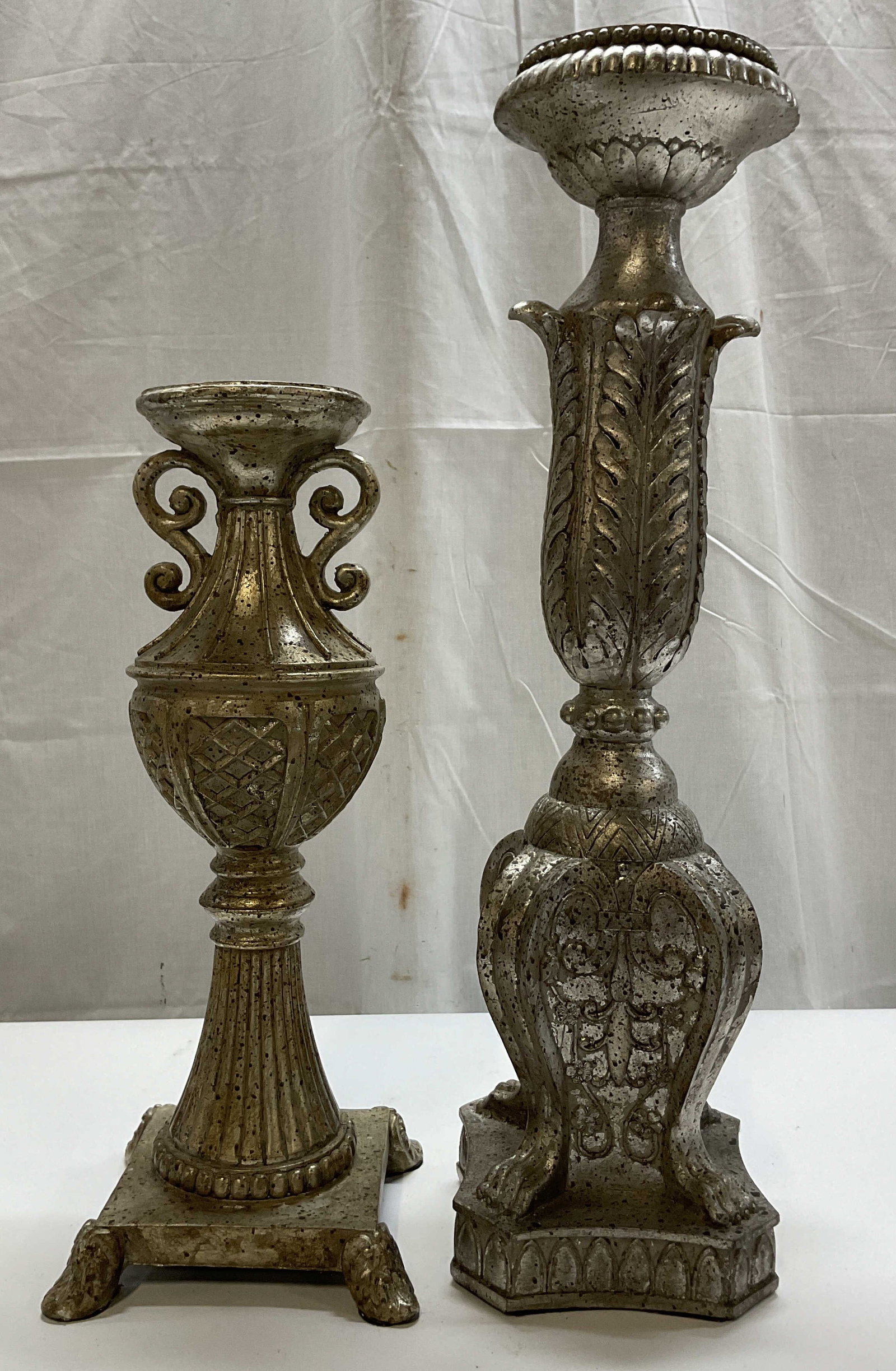 Lt2 Silver Tned Deco Pillar Candlestick Holders: Lot of 2 silver toned decorative pillar candlestick holders. Resin material. Flat tops. Decorative scroll and leaf motifs. Neoclassical style architectural design. Footed base and claw feet. Ribbed su