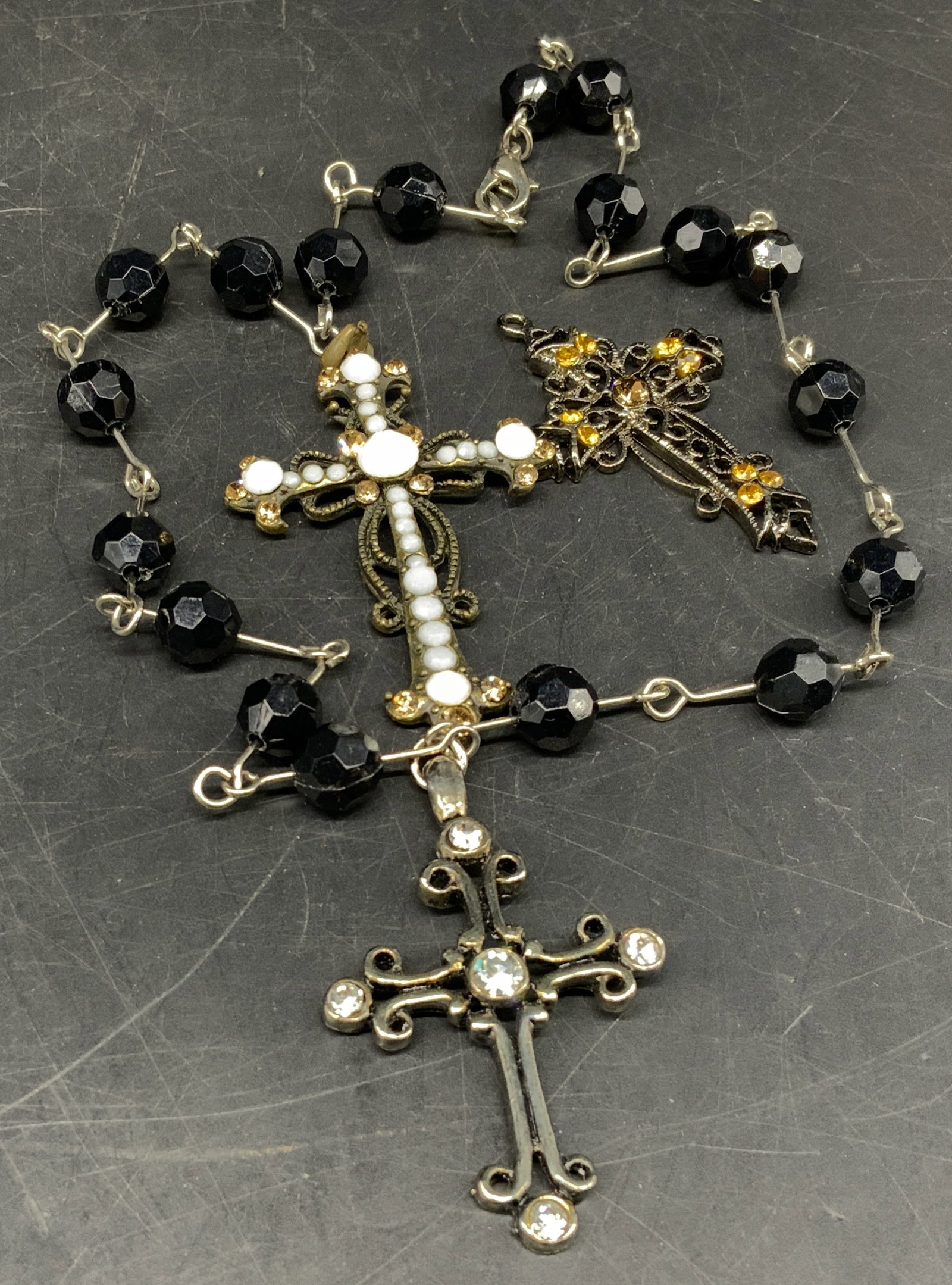 Lt3 Vintage Rosary & Cross Pendants: 3 Vintage Religious Jewelry Items. Includes rosary with black beads and cross pendant with white rhinestones, a brass-toned cross pendant with white beads and yellow rhinestones, and a silver-toned cr