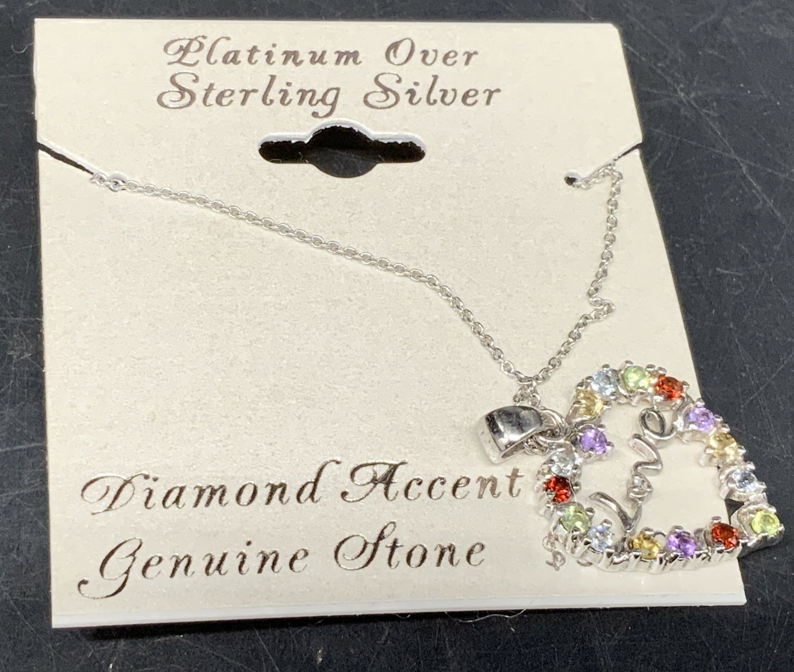 Platinum Over Sterling Open Heart Necklace Italy: Platinum Over Sterling Open Heart Pendant Necklace On Original Display Card. Marked 925 with makers mark RSE. Italy. Reads Love inside heart. Diamond accents and genuine multi-colored stones. Appears 