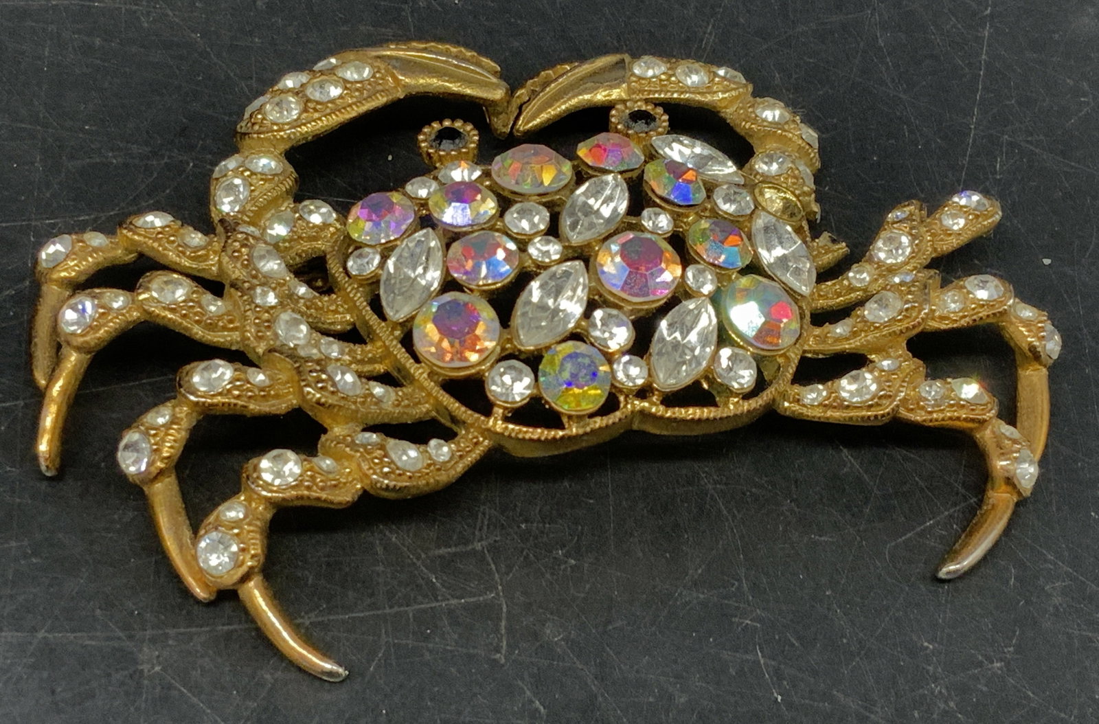 Vintage-Style Figural Crab Brooch: Vintage-Style Figural Crab Brooch. Gold-Toned with white and Aurora Borealis rhinestones. Round and marquise cuts. 2 broken legs and broken clasp. Missing stone. Coating loss present. Measures app 2.7