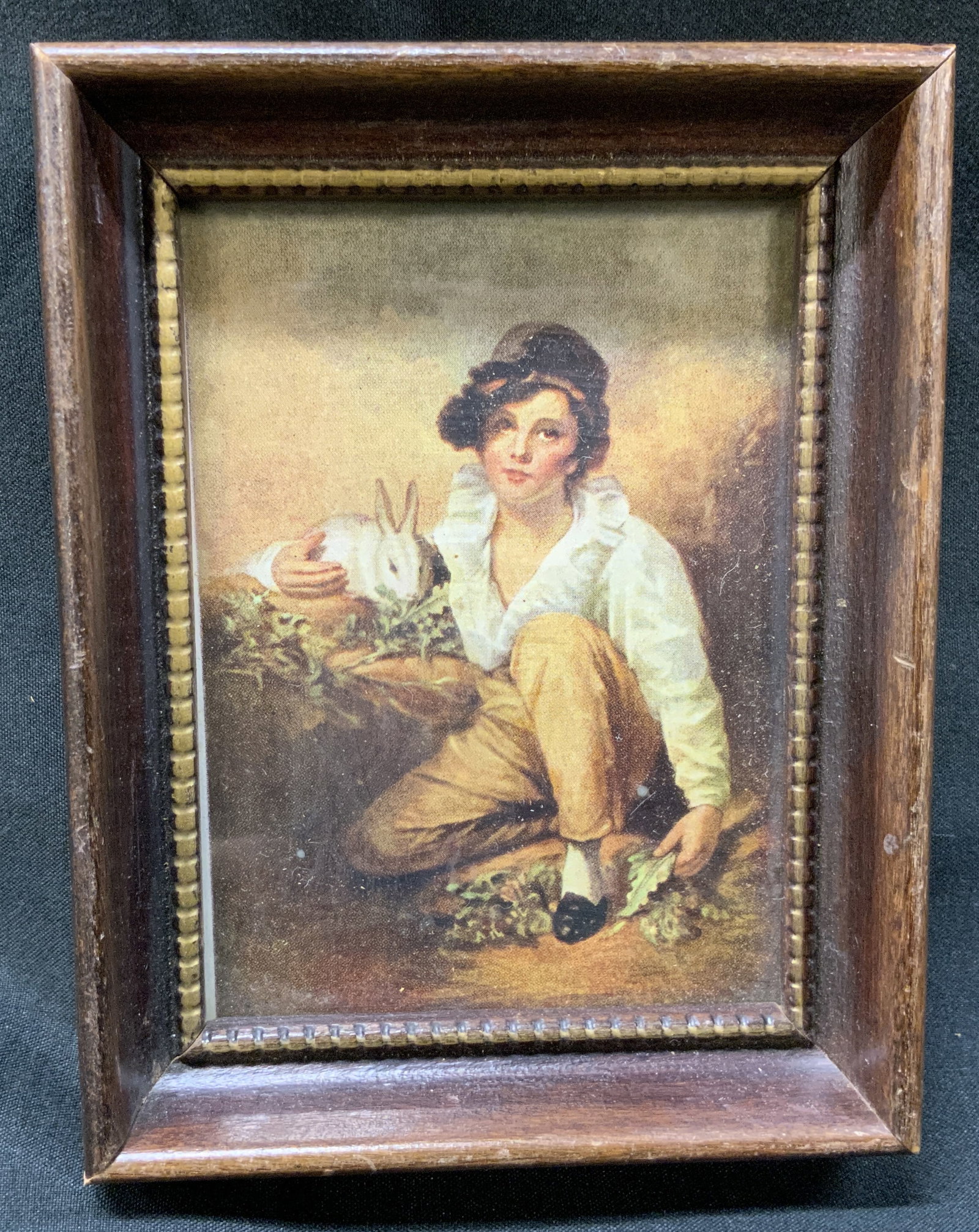 Vtg Raeburn Boy+Rabbit Frmd Print: Vintage miniature art print of Boy and Rabbit by Sir Henry Raeburn. Printed Reproduction of original painting. Framed in deeply recessed dark wood frame with beaded inner border. Condition consistent 