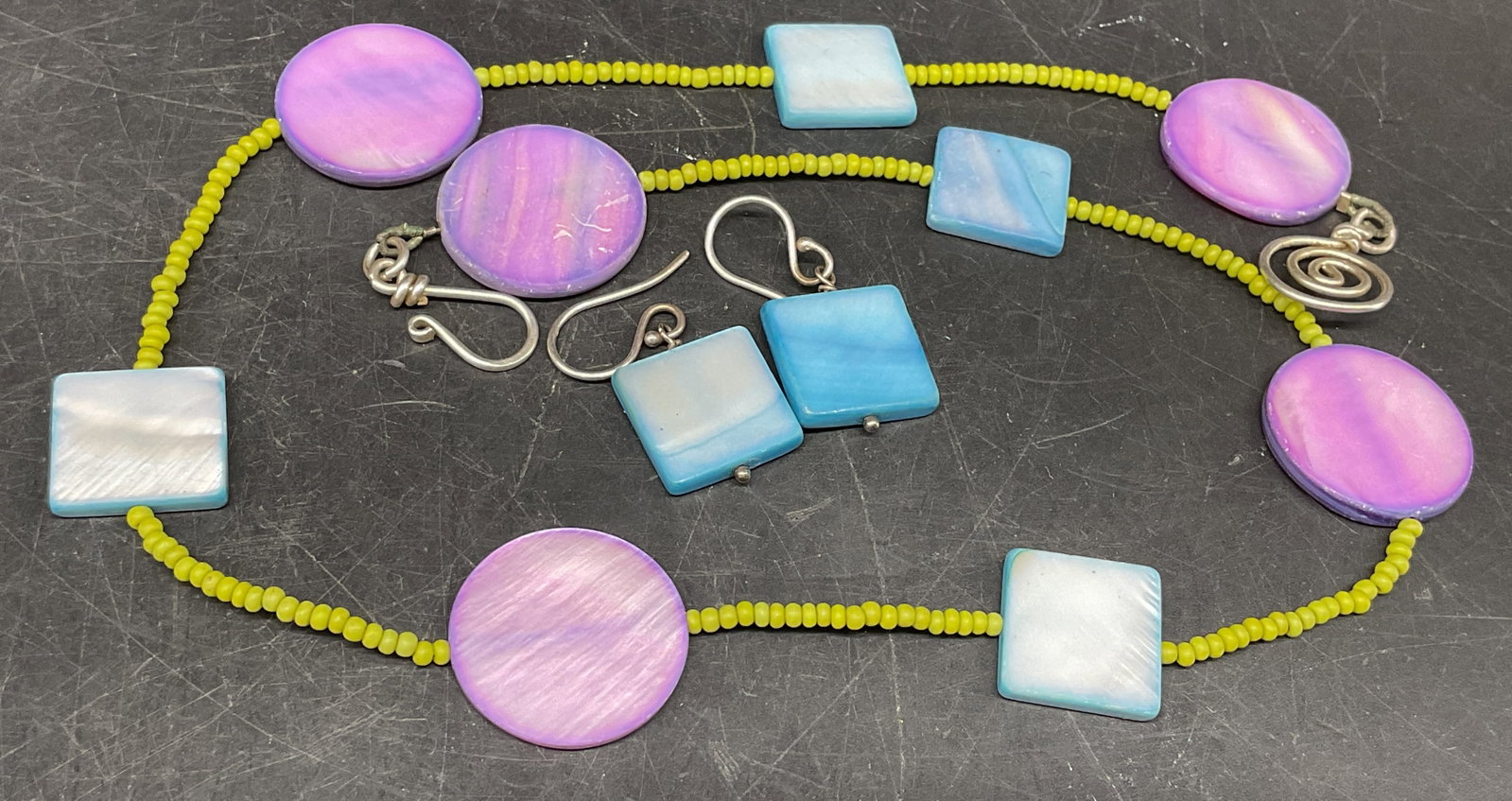 Dyed Mother-Of-Pearl Beaded Jewelry Set: Beaded Jewelry Set. Circular purple and square blue dyed mother-of-pearl beads spaced by lime green seed beads. Scratching and corrosion present. Necklace measures app 17in L. necklaces, beads,