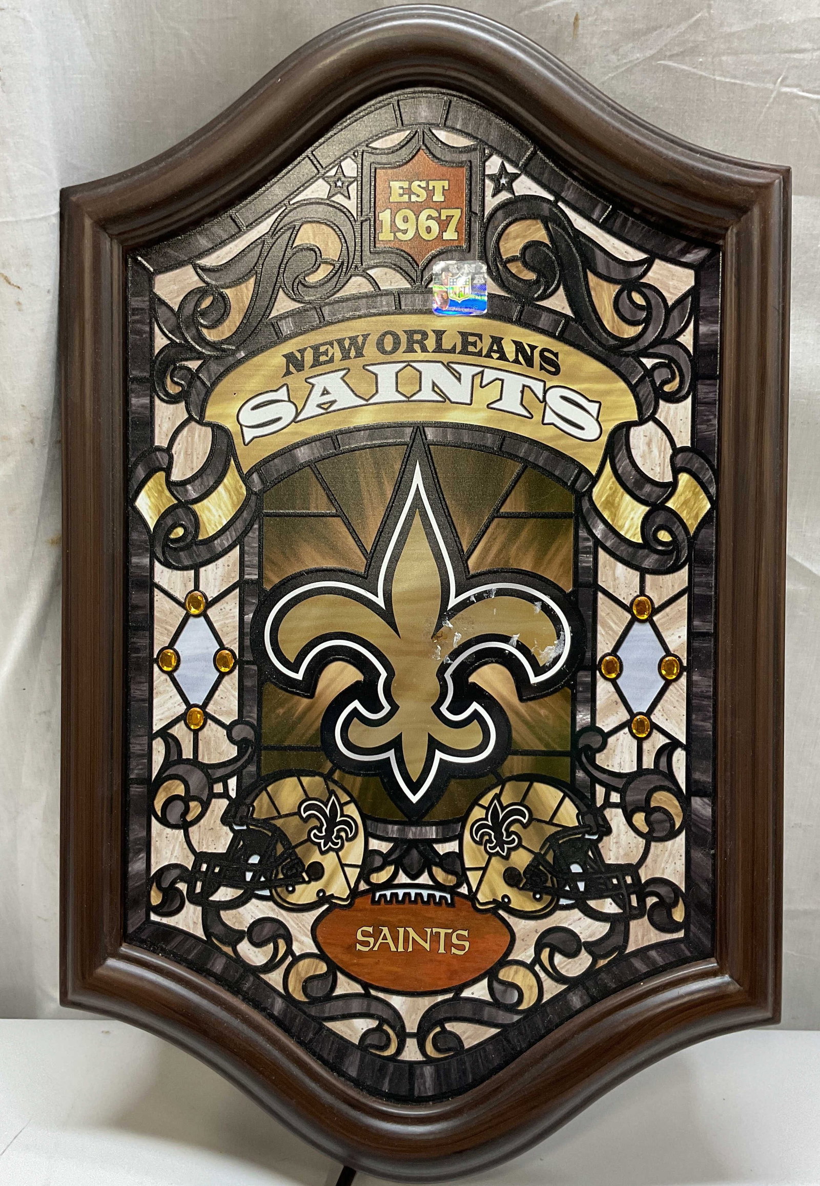 2016 Bradford Exchange Saints Illum Stained Glass: 2016 Bradford Exchange New Orleans Saints Illuminated Stained Glass wall decor. Marked on backside, as photographed here. Arched wooden frame. Surface reads EST 1967 New Orleans Saints. Embellished wi