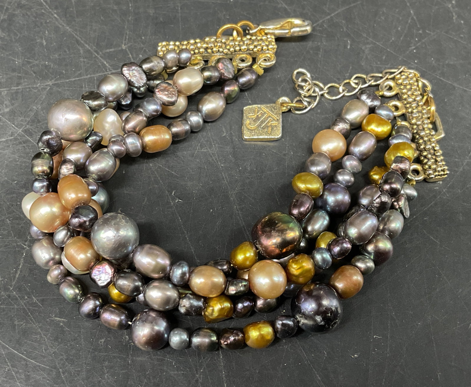 KJK NYC Multi-Colored Freshwater Pearl Bracelet: KJK NYC Multi-Strand Cultured Bar Freshwater Pearl Bracelet. Grey, metallic, and white tones. Condition consistent with age and exposure. Measures approx 5.5in across bar with additional in across