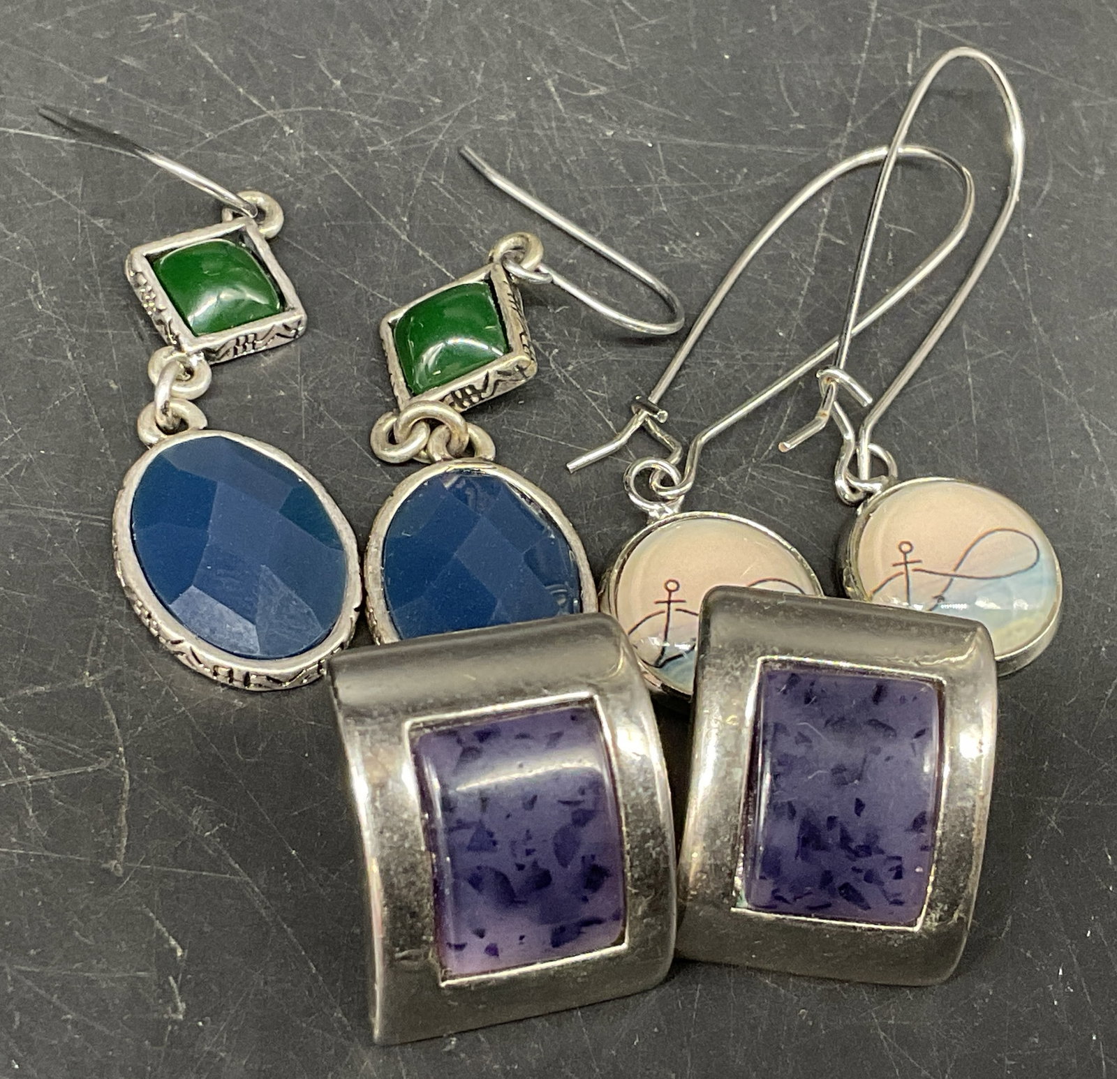 Lt3 Pairs Lia Sophia+ Silver-Toned Earrings: 3 Pairs of Silver-Toned Earrings. Includes Lia Sophia rectangular earrings with purple glass center, geometric tiered earrings with green and blue glass stones, and infinity loop design in glass