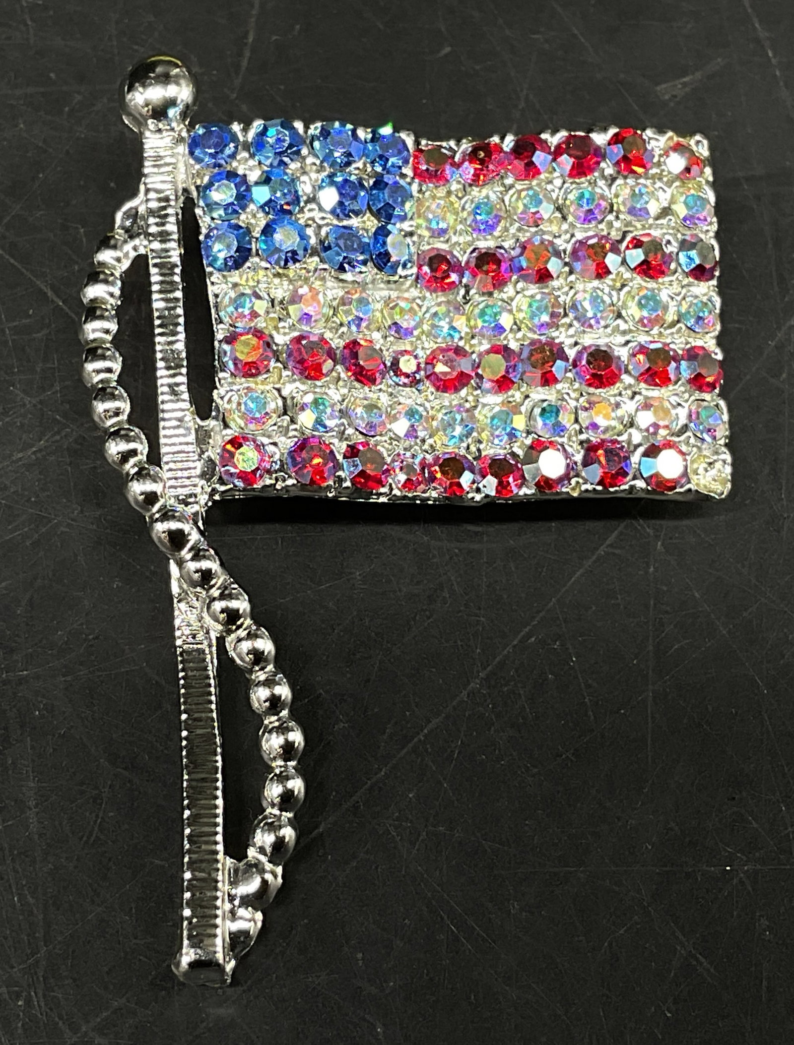 Vtg Sgnd Dodds Rhinestone American Flag Brooch: Vintage Signed Dodds Silver-Toned American Flag Brooch. Red, white, and blue rhinestones. Beaded rope trim loops going down side of mast. Condition consistent with age and exposure. Measures app