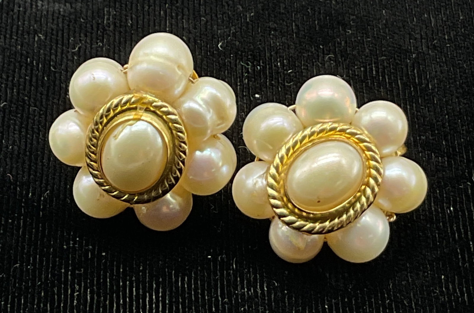 Vintage Pearl & Gold Toned Clip On Earrings: Vintage Pearl and gold toned clip on earrings. Floral cluster design. Braided rope style texture. Central Pearl. Clip on closure. Measures approx 1 inch in diameter. Scratching and surface wear.
