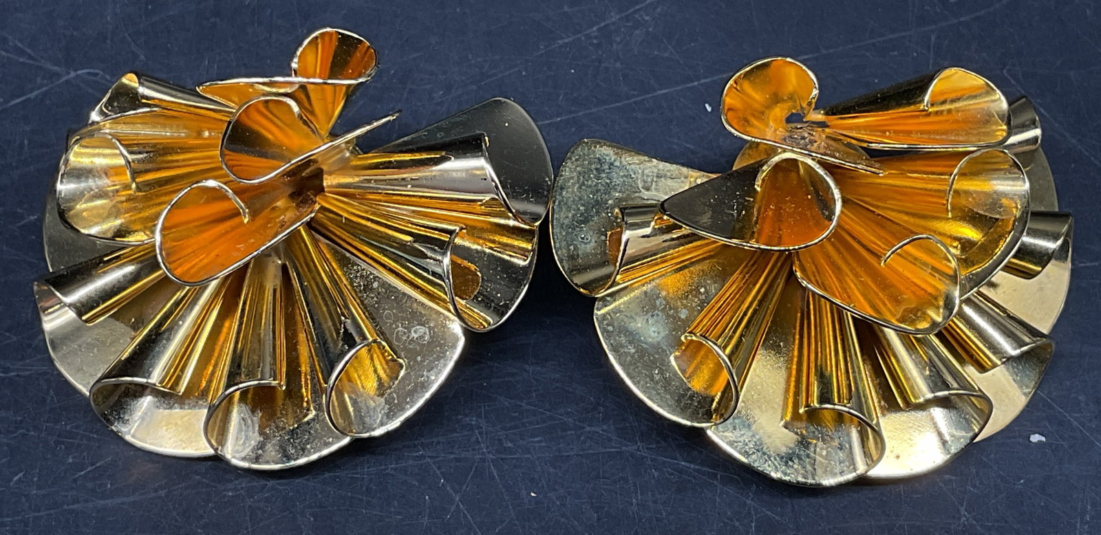 80s Signed Lee Angel Gold-Toned Earrings: Vintage 1980s Signed Lee Angel Gold-Toned Pleated Ribbon Earrings. Manhattan based fashion jewelry. Designed by Roxanne Assoulin. Some wear to ear padding. Measures 2in Diam. vintage earrings,