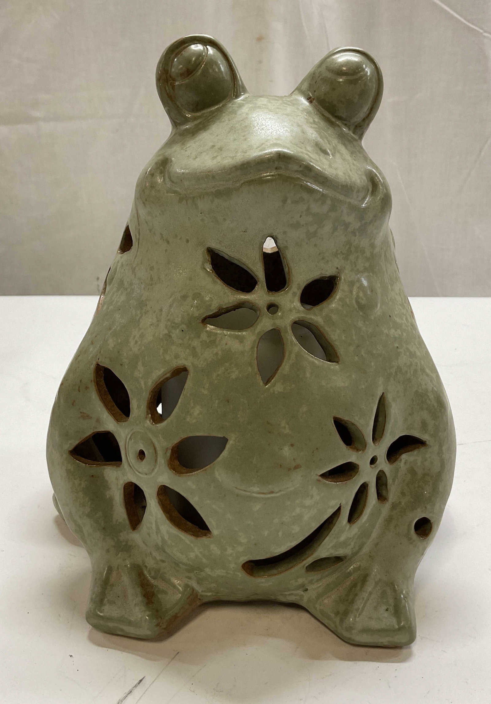 Vintage Ceramic Outdoor Frog Light Statue: Vintage ceramic outdoor frog light statue. Light green glazed frog statue. Detailed features. Cut out floral motifs, lets light shine. Measures approx 7 x 8 x 9 inches. Not tested for function, sold