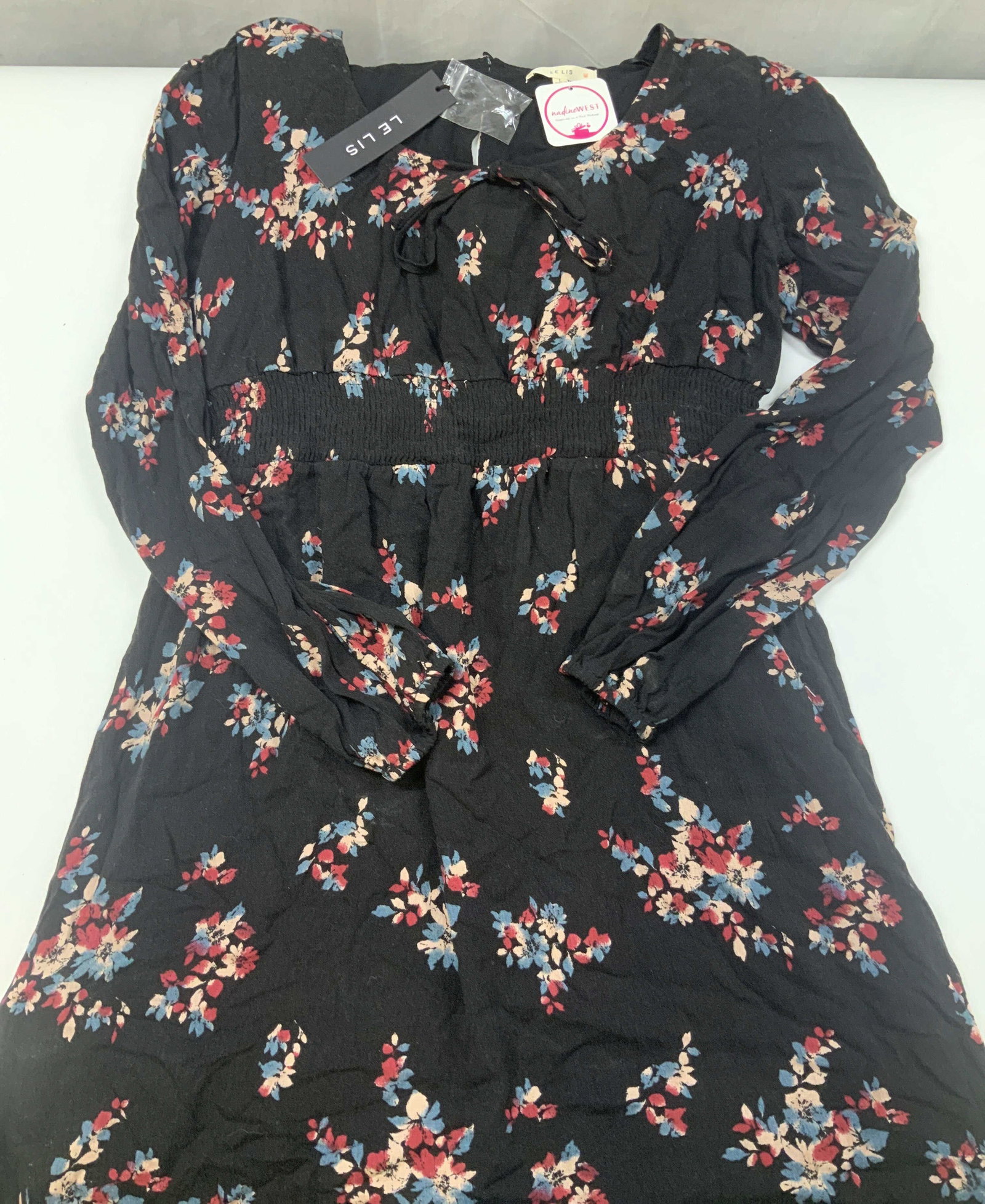 LE LIS floral long sleeve mini dress, NWT: LE LIS floral long sleeve mini dress. New With Tags. Made of 100% rayon in size large. Features a floral pattern over a black base. Constructed with a. Wide structured smocked elastic waistband that