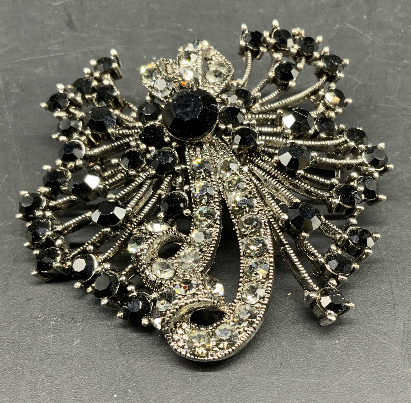 MD Sgnd rhinestone Crystal Statement brooch: Signed MD, this is an ornate vintage rhinestone brooch featuring a central black crystal surrounded by clear and black rhinestones set in a silver tone sunburst framework, sometimes categorized as