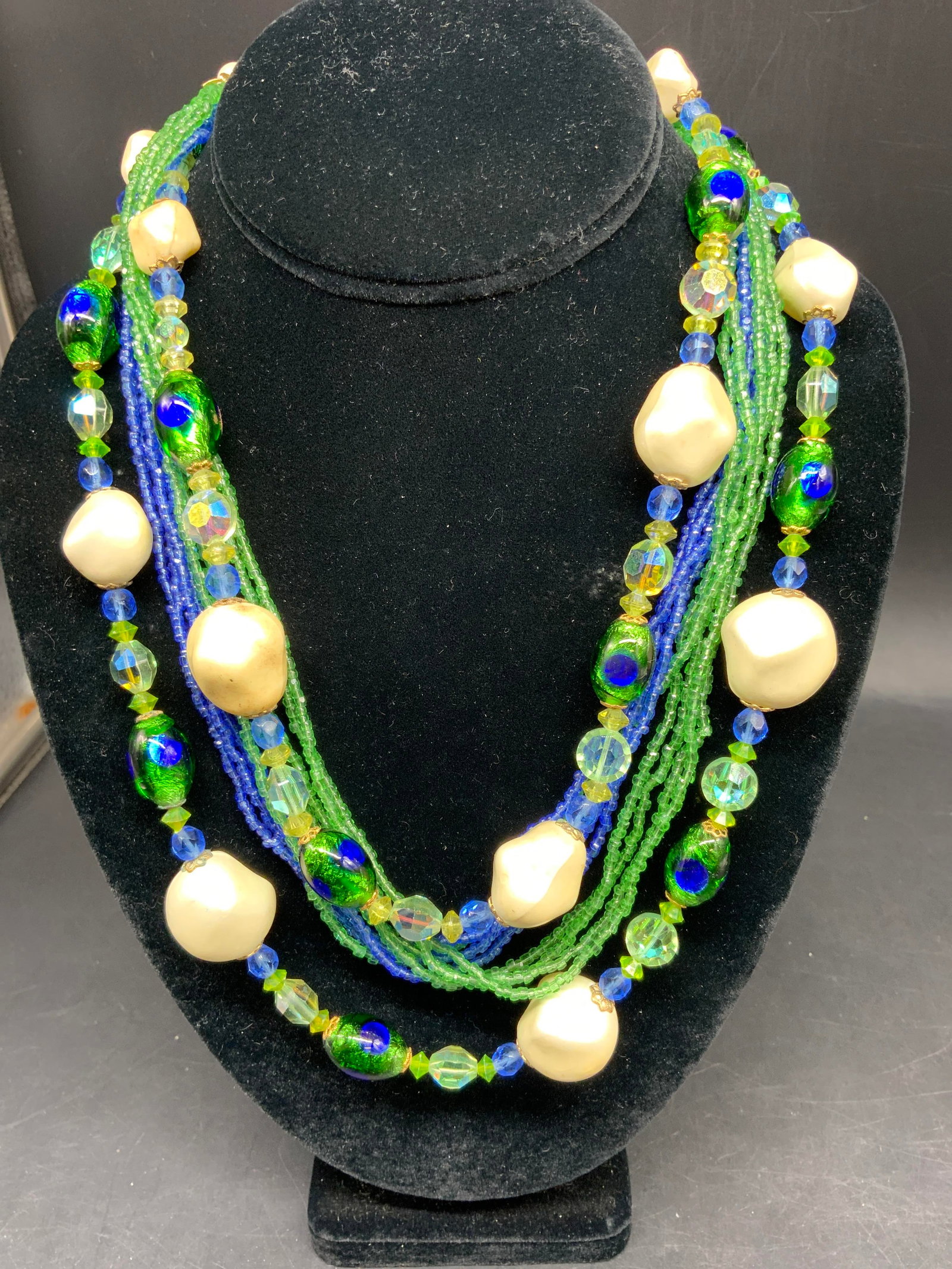 Vntg Muti Strand Art Glass Statement Necklace,: Vintage multi strand statement necklace featuring a mix of green blue art glass , possibly MURANO, beads, seed beads, and irregular cream colored baroque beads, layered design with mid century vintage