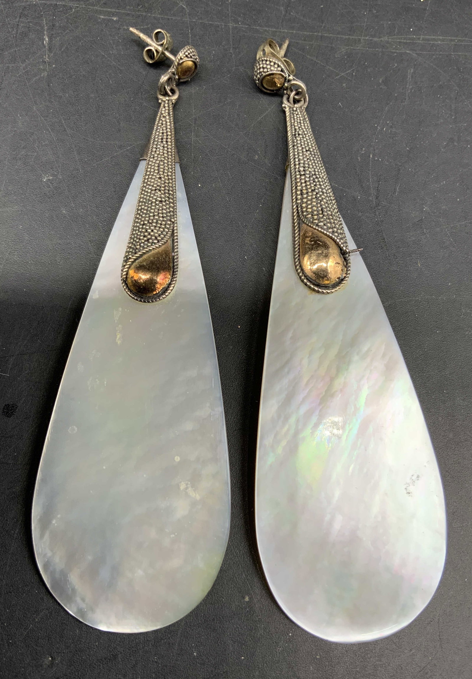 Sterling and Mother-of-pearl White earrings, 4 in: Marked 925, Statement Earrings featuring tear drop shaped white mother of pearl shell suspended from textured sterling silver post and two tone drop accent details, each measures ht 4 inches, estate