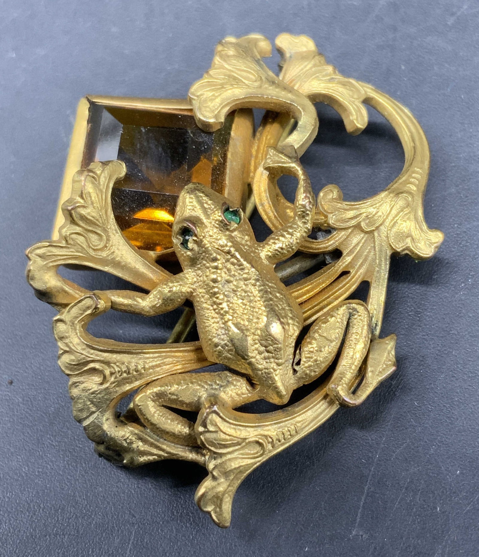 GNS Sgnd Antique Art Nouveau Frog Brooch: George Steere Antique Art Nouveau Frog Brooch featuring emerald green glass accented eyes a prominent step cut amber topaz glass gemstone set into an organic flowing foliage background, design