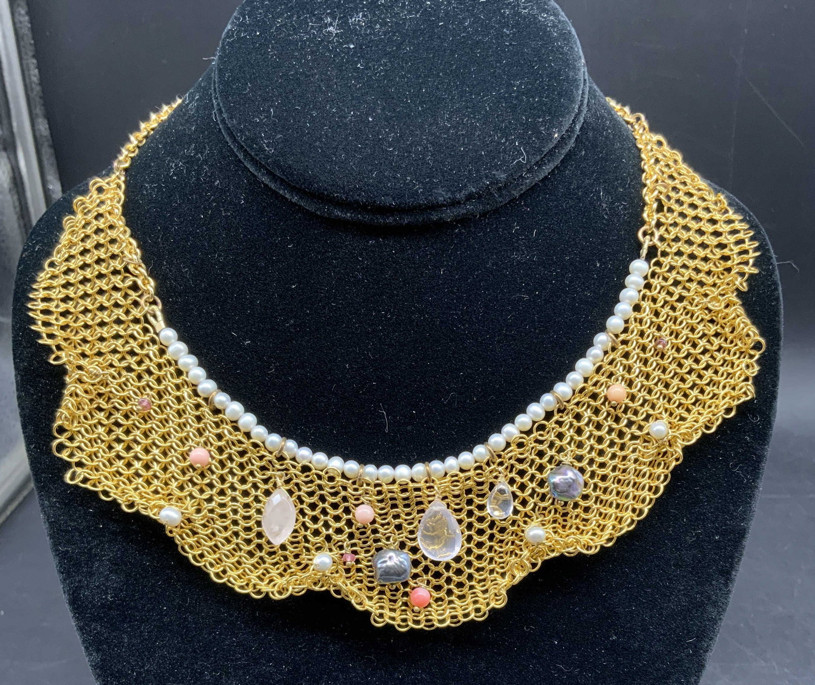 Alexis Bittar Gold Tn Stone Crystal Bib Necklace: Signed Alexis Bittar Bib necklace, crafted with a flexible gold toned chain Mail mesh collar structure, adorned with a delicate row of small white pearls running along the upper curve and accented by