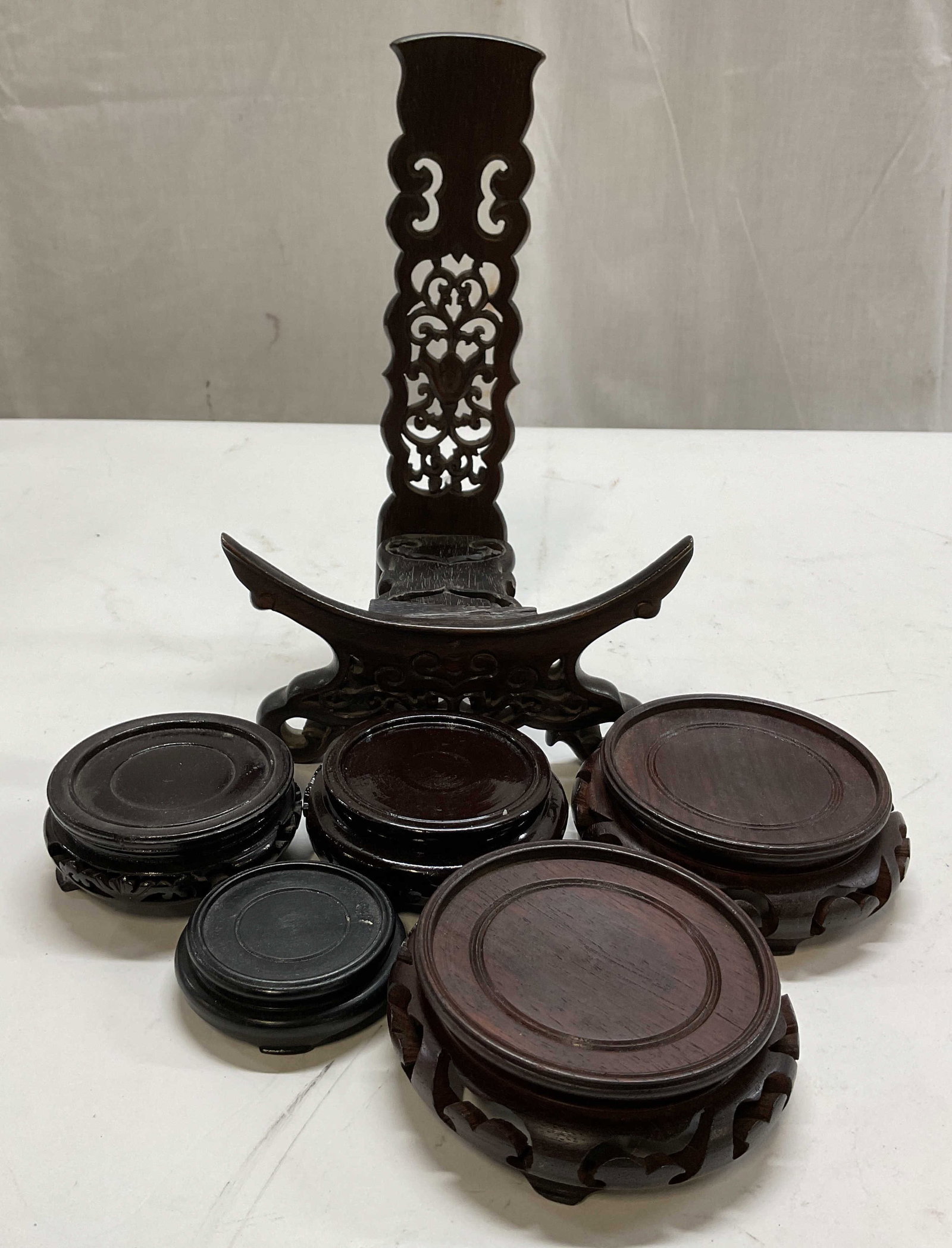 Lot 6 Assort Wooden Display Stands Japan Hong Kong: Lot of 6 assorted wooden display stands. Some marked made in Japan, made in Hong Kong. Round footed stands and footed easel stand. Ornate scroll designs. Shape, design, and size vary. Largest