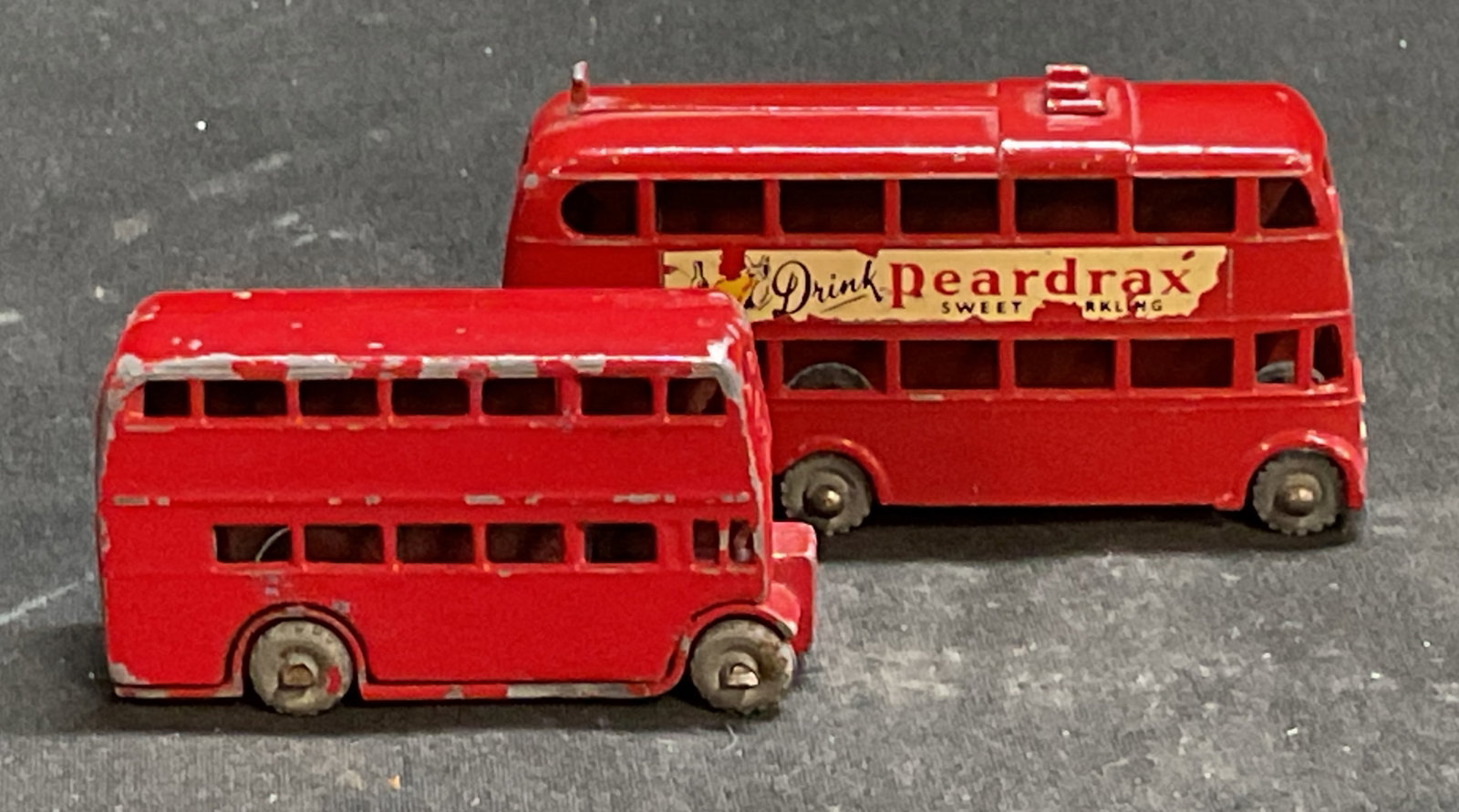 Vtg 50s-60s Lesney Diecast Model Buses England: Vintage Circa 1950s-1960s Lesney Diecast Model Buses. Red painted finish. Features a London double decker bus and a London trolleybus. England. Paint loss present. Largest measures app 1.5in H x 2.5in