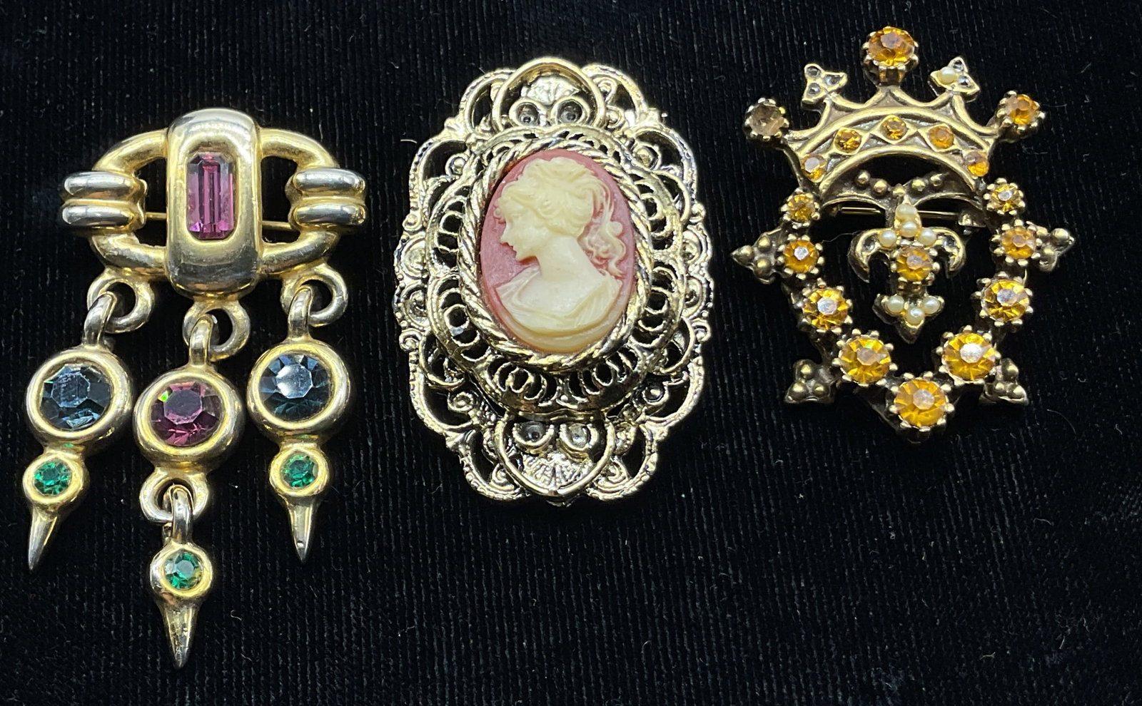 Lot 3 Vtg Assorted Gold Toned Brooches Gerrys+: Lot of 3 vintage assorted gold toned brooches. Oval shaped with openwork filigree frame and cream and pink profile portrait in center, backside marked Gerrys. Heart and crown shaped brooch with orange
