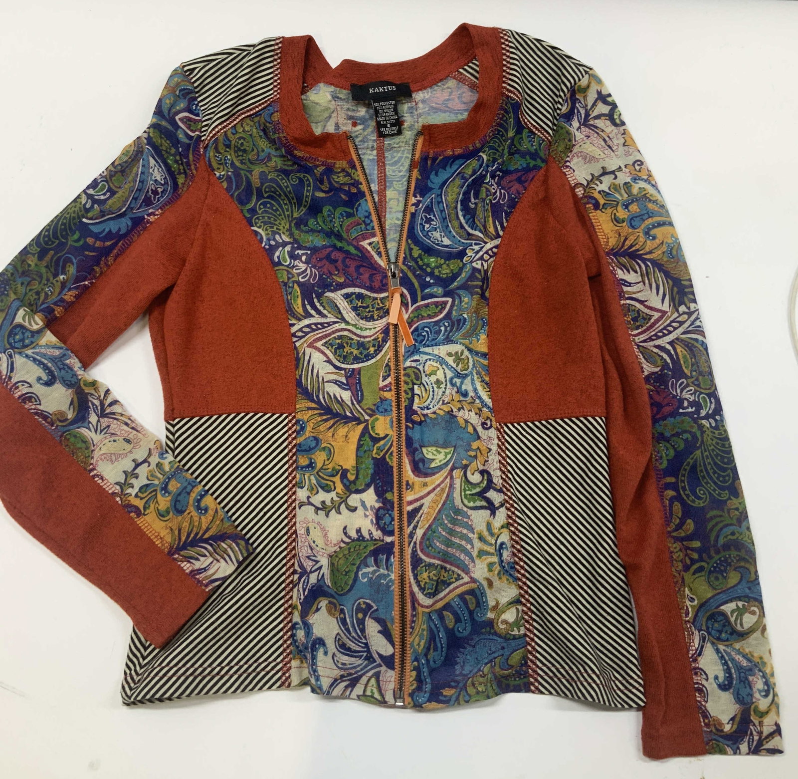 Vntg KAKTUS patchwork zip front jacket: Vintage KAKTUS patchwork zip front jacket. Size small. The jacket combines an intricate multi colored paisley print, with a black and white stripe pattern, as well as a solid rust red patchwork design