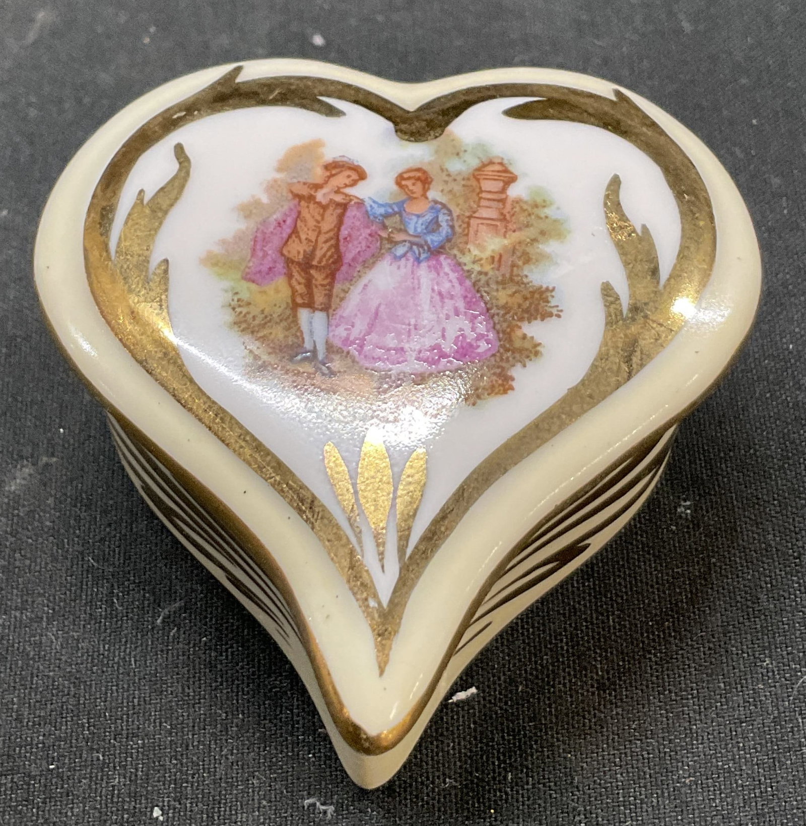 G. Simonnet Limoges Porcelain Trinket Box France: G. Simonnet Limoges porcelain heart shaped lidded trinket box. Marked on underside, made in France. Heart shaped box. Hand painted. Courting couple motif with gilt scroll accents. Varying colors.