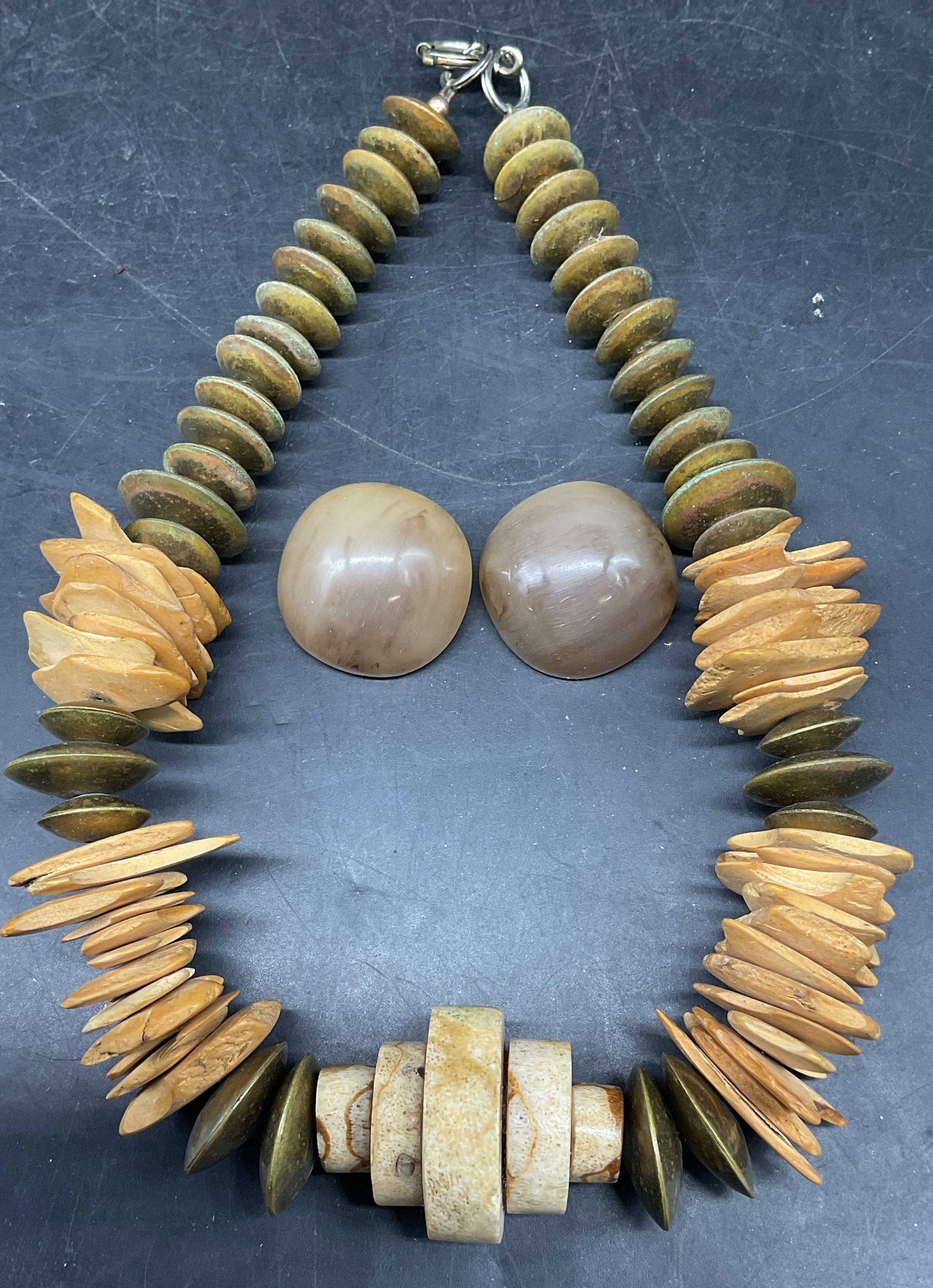 Lot 2 Vtg Gold Tone Bone Style Necklace +: Lot of 2 jewelry pieces. Gold tone and bone style beaded necklaces. Drop length measures approx. 7 inches. Grey lucite round stud earrings. Measures approx. 1 inches long wide. Some scratching.