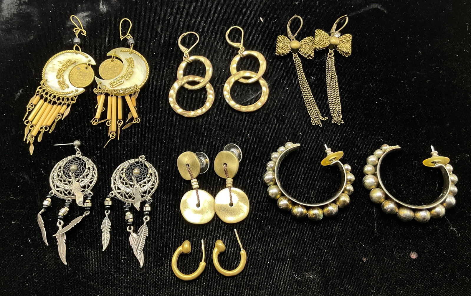 Lot 7 Vintage Assorted Dangle Earrings: Lot of 7 vintage assorted dangle earrings. Gold toned disc shaped dangle earrings. Gold toned hoop shaped earrings with distinct ball tip. Gold toned crochet bow tie dangle earrings with clear rhinest