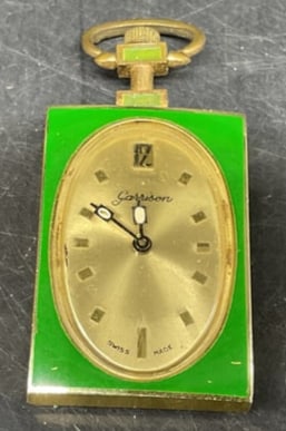 Vtg 60s-70s Garrison Swiss Made Pendant Watch: Vintage Circa 1960s-1970s Garrison Swiss Made Pendant Watch. Gold-Toned aluminum with green enamel border. Scratching and loose cover. Not tested for functionality. Measures app 2in H x 1in L. vintage