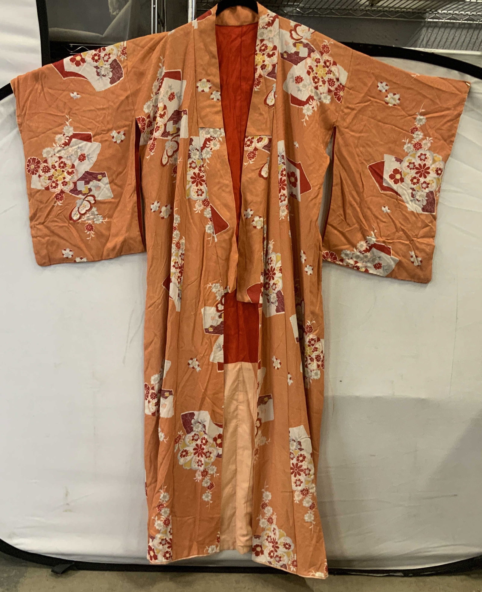 Vntg Japanese silk orange floral kimono: Vintage Japanese orange floral kimono. Crafted from woven silk it features a vibrant , traditional orange color. The interior shows a red lining on the upper half. The pattern utilizes classic Japanes