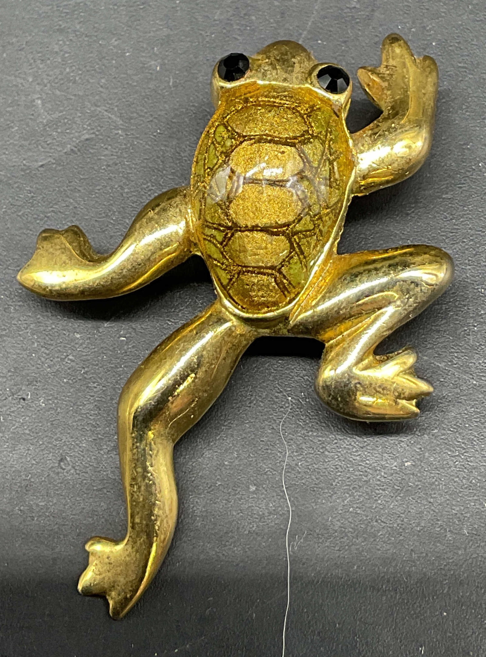SGND Vtg SJ Gold Toned Enamel Frog Brooch: Signed vintage SJ gold toned enamel frog brooch. Surface is signed SJ. Enameled detailed features. Black glass eyes. Measures approx 1 x 1.5 inches. Scratching. Jewelry, brooch, SJ, estate jewelry, co