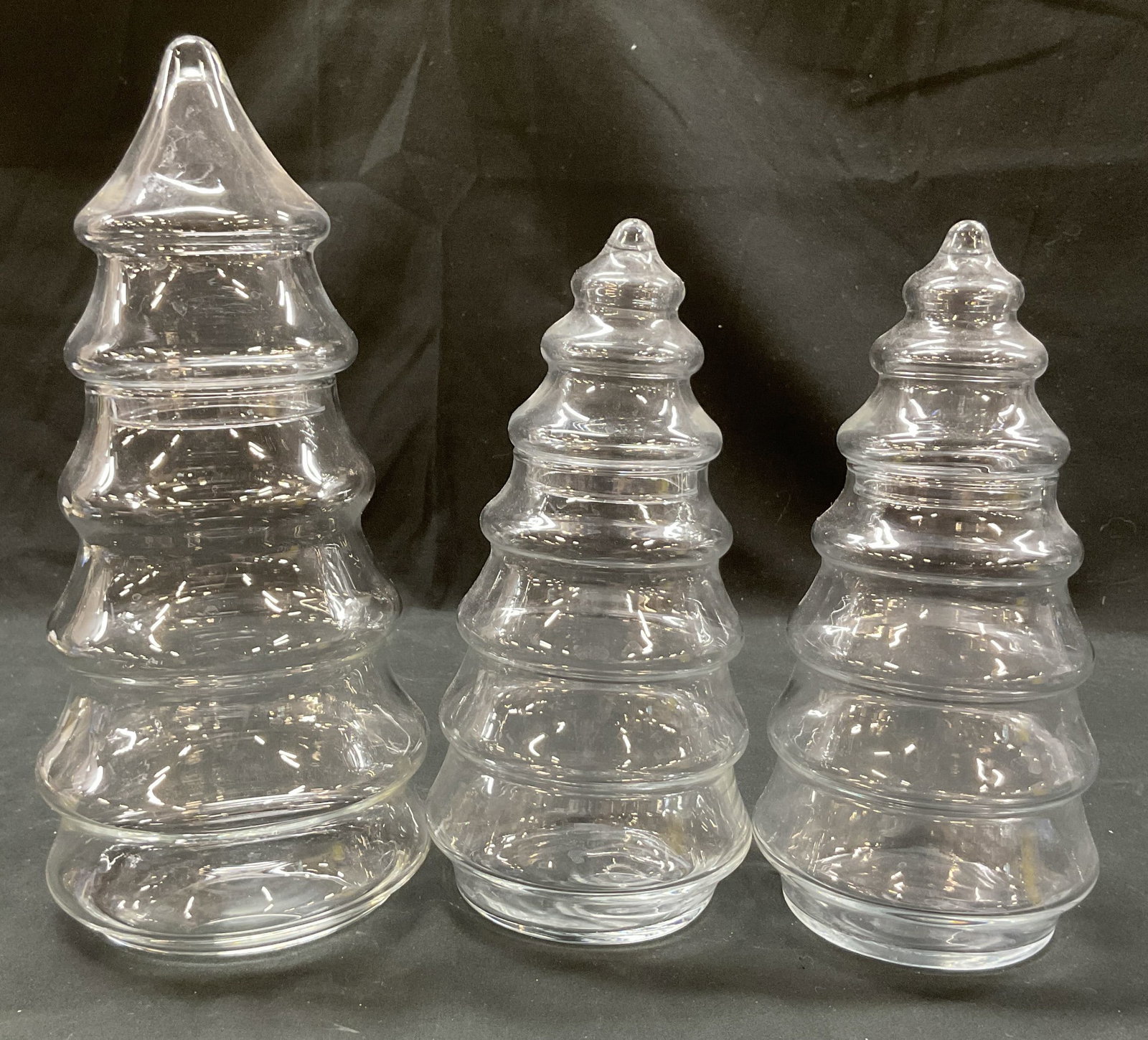 Set 3 Vtg Clear Glass Xmas Tree Lidded Jars: Set of 3 vintage clear glass Christmas tree lidded apothecary jars. Varying sizes. Stacked multi tier design with matching lid. Largest measures ht approx 11 inches diam approx 4.5 inches. Scratching.