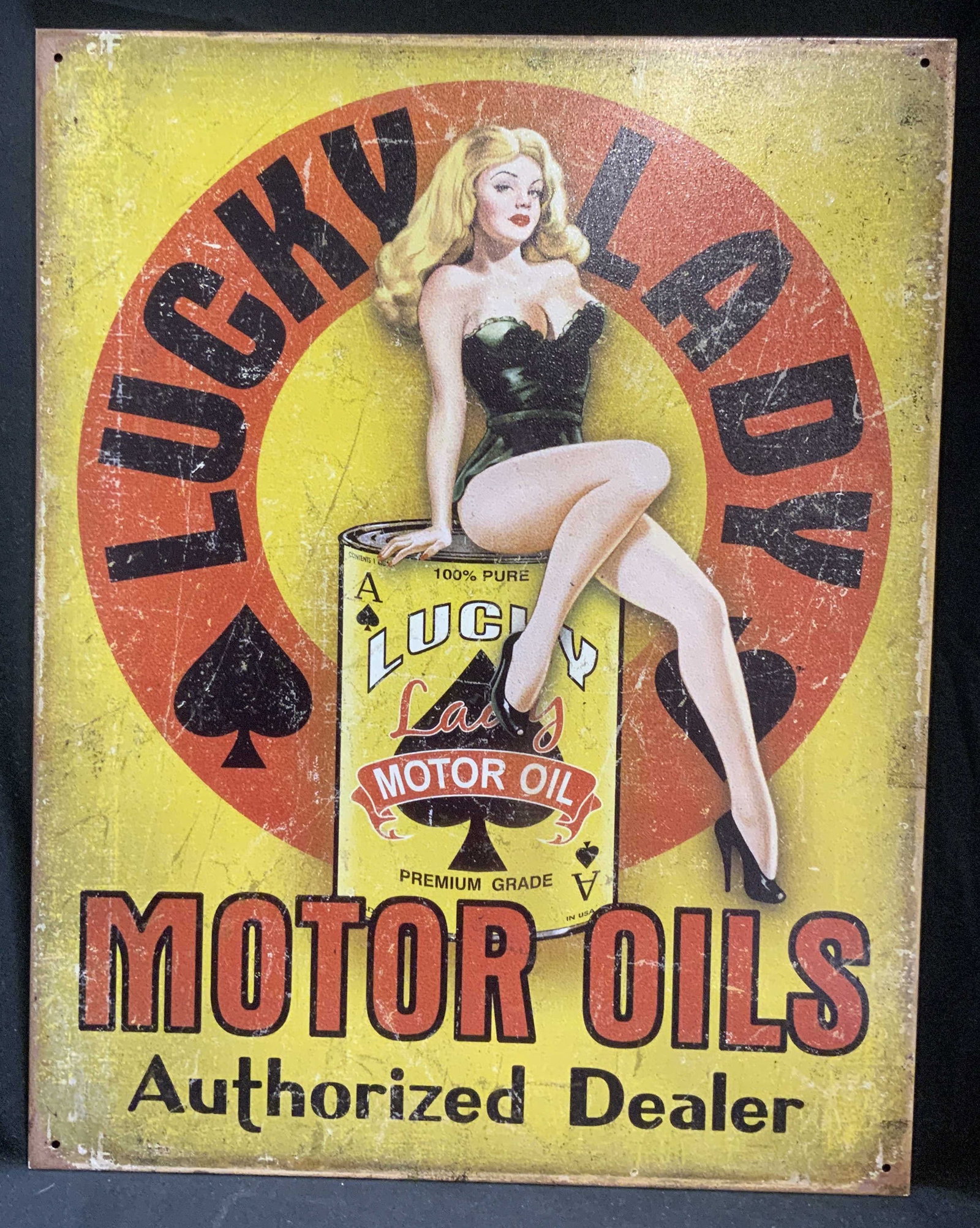 DE Gderbyshire Lucky Lady Motor Oil Tin Sign: Desperate Enterprises and Gderbyshire Lucky Lady Motor Oil Tin Sign. Vintage-Style design of a pin-up model sitting on an oil drum. Modeled after 1940s-1950s gas station ads. Condition consistent with