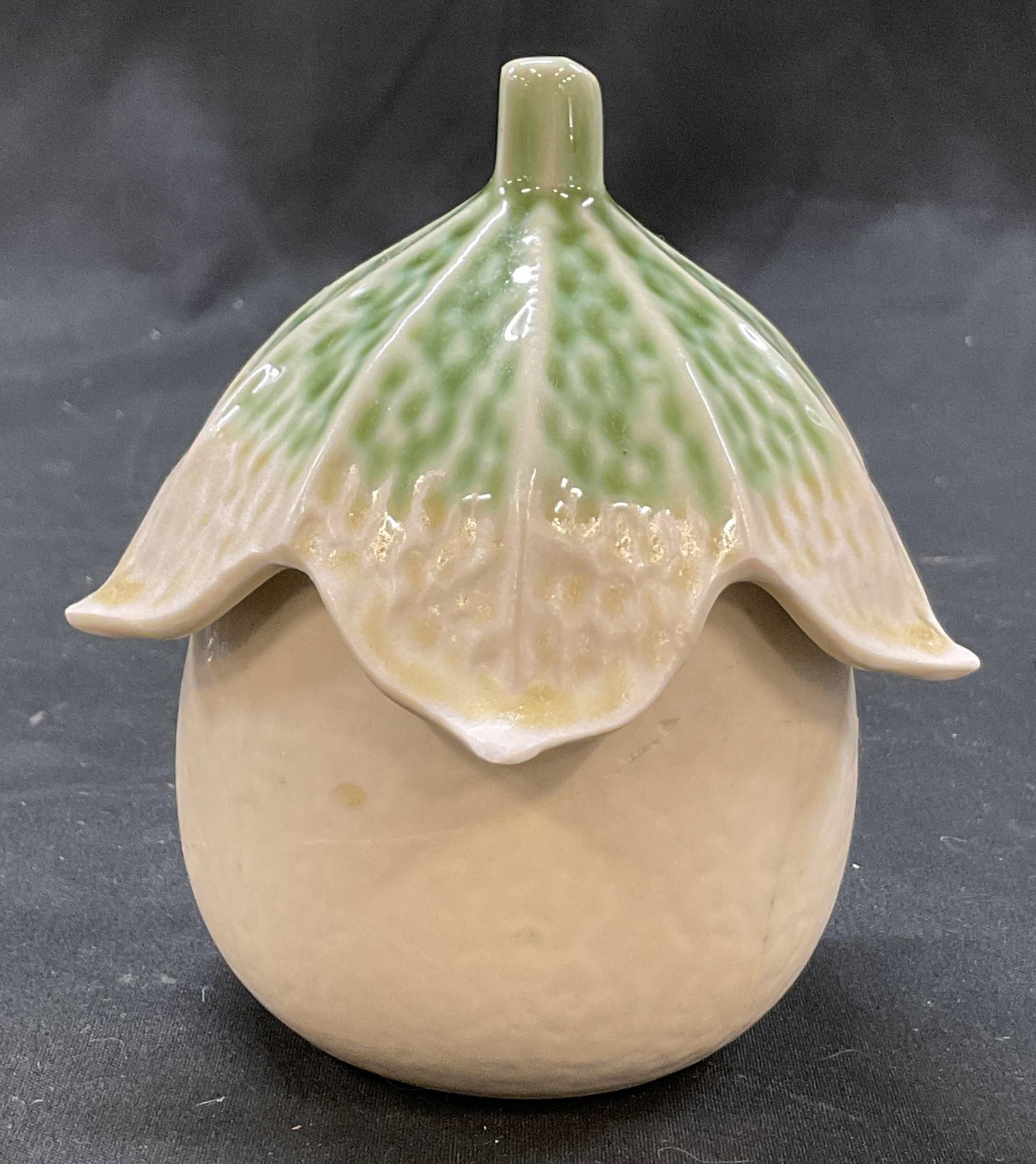 Vintage Ceramic Eggplant Lidded Jar Japan: Vintage ceramic eggplant lidded jar. Marked made in Japan on underside. Green and white scalloped textured lid, finial, stylized leaf design. White textured jar. Glossy finish. Measures ht approx 4 in
