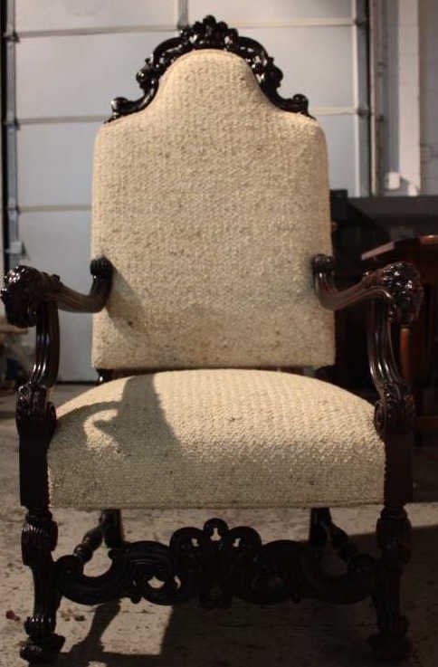 Ornately Carved Upholstered Statement Throne Chair: Height 53 inches. Width 27 inches. Depth 22.5 inches. Mahogany frame. Lion head carved arms. Pristine condition.