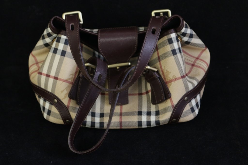 Burberry Handbag: Burberry handbag with signature leather pattern. Buckle leather straps & fabric lined interior. "BURBERRY" on buckles. Consignor bought purchased in The Westchester mall.