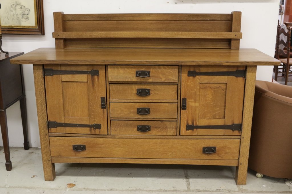 Stickley Oak Strap Hinge Sideboard: Iconic Arts & Crafts design. Early 20th century. Excellent condition. Four center drawers with hand forged iron, two side cabinets and one long drawer. 12 inch back splash plate holder. Measurements H