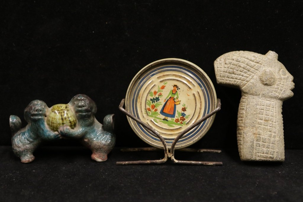 Assorted Antique Table Articles: One carved stone head. One glazed and painted Foo dog statue. Four "quimper" plates with stand. Height of plate on stand 3. 5 ". From the estate of Scarsdale, NY family that lived in Asia from 1940-19