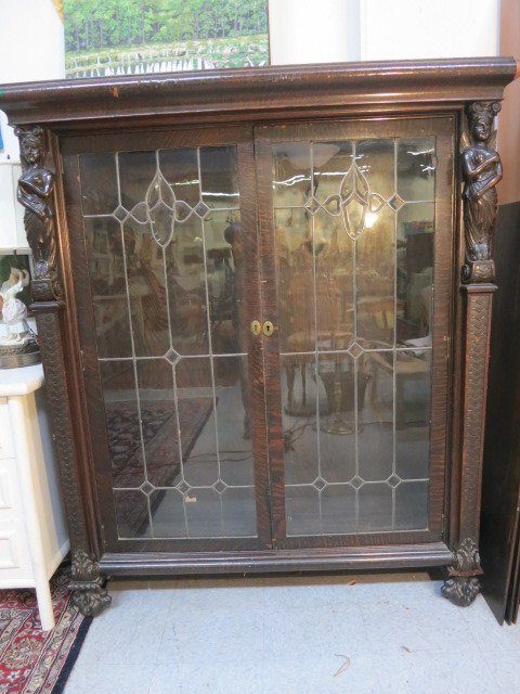 Antique Mahogany Roman Goddess Framed Cabinet: European continental unique piece, With leaded & beveled glass doors & two feet high, carved Roman Goddess sculpture topped pilasters & columns. Carved ball & clawed feet. Ogee crown. Double brass loc