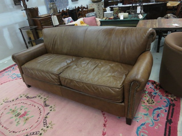 BLOOMINGDALES Leather Couch Brass Nail Heads: Labeled for Bloomingdales, soft tobacco colored leather sofa with tight back and scrolled arms. Three loose cushion seat. Trimmed with large brass nail heads. Scrolled back detail.