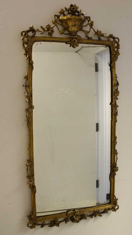 Antique French Gilded Carved Regency Mirror 19th c: Ornately carved and beautifully gilded Antique French Regency style mirror with replacement smoked glass. circa 19th century. Carving of classic elements Floral basket motif on top. Purchased in Franc