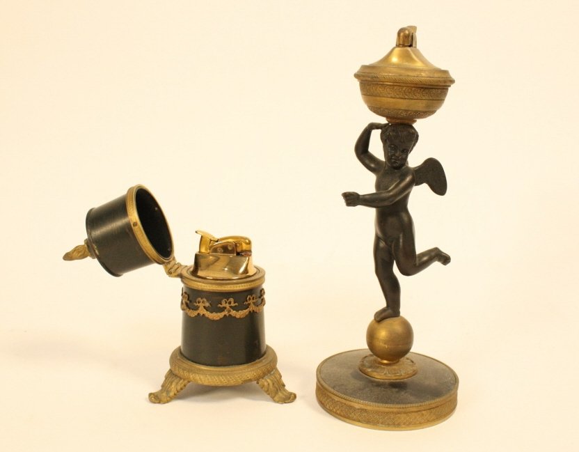 Pair French antique bronze and blackstone lighters: One black stone putti mounted on gilded bronze base and one in decorative cylinder form with black porcelain. Tallest measures nine inches. Elegant table decorative accessories. French Antique Collect