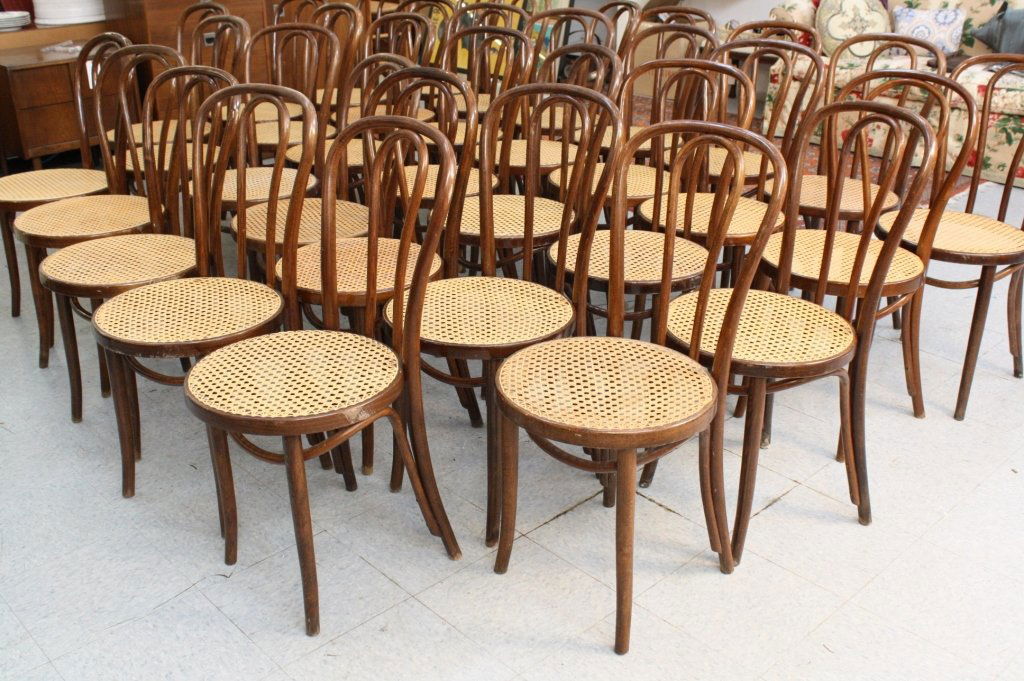 Set of 8 French Bistro chairs: Each Walnut chair has bentwood back of double loops and caned seats. Measure 36 inches high and 16 inch seat diameter. Has label affixed to bottom reading ZPM Radomsko and numbered. Property of Greenw