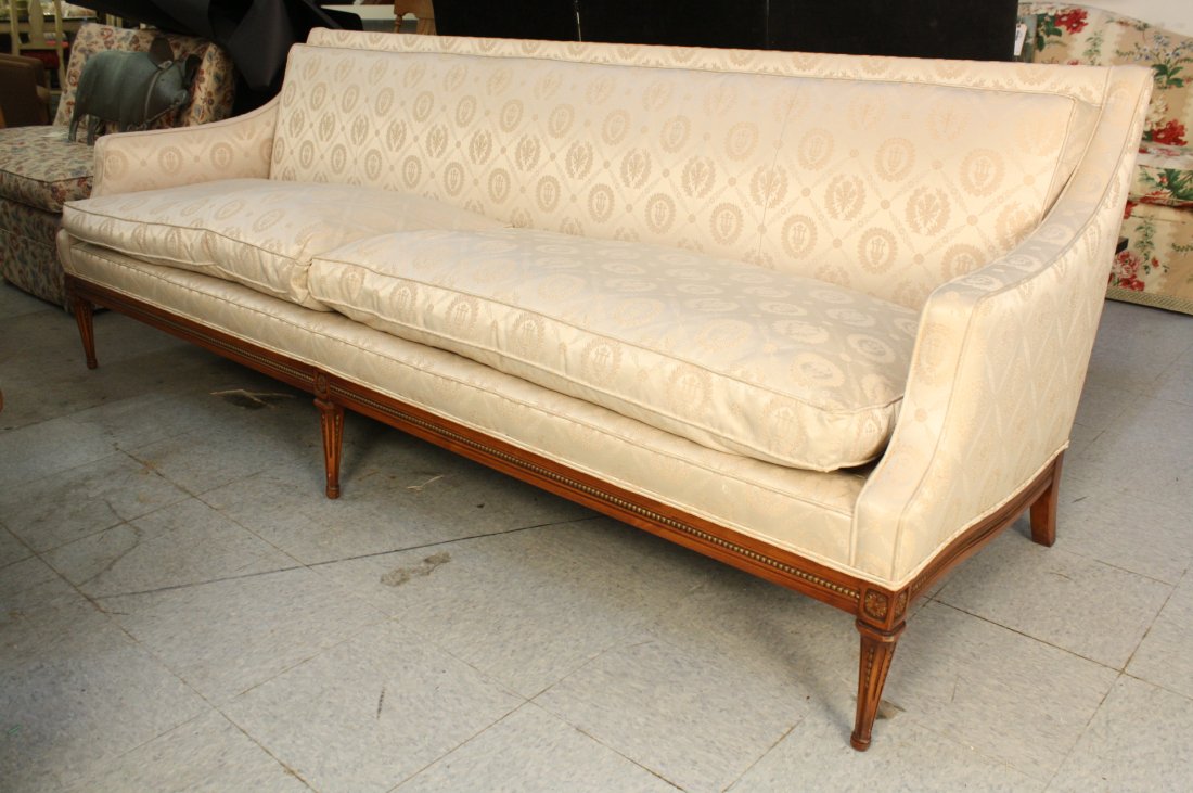 Vintage sofa with hand carved frame: Vintage Sofa with hand carved frame. Slim simple lines and trim profile. Carved and fluted base and feet with corner florettes. Upholstered in pale grey silk. Measures 87 inches long. 33 inches deep. 