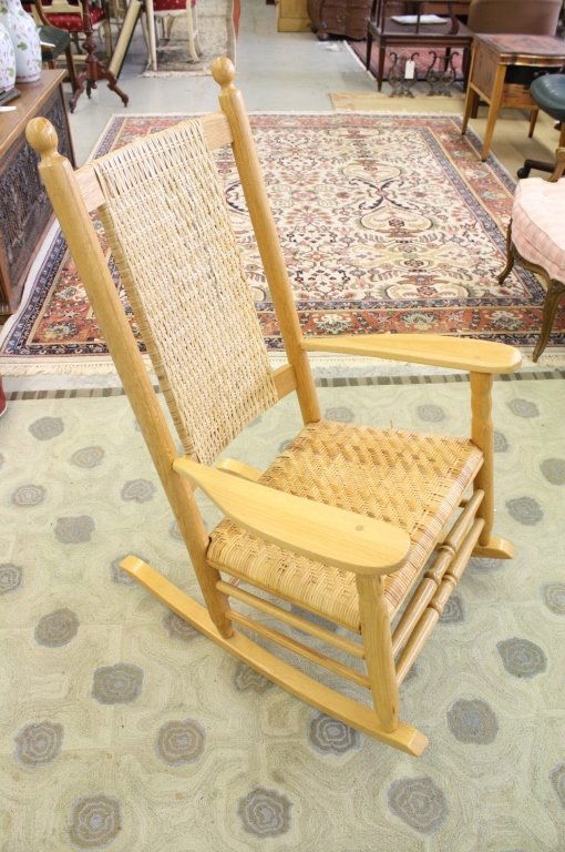 Adirondack style rocking chair: Slid Pine construction wide lank arms, rush seat and rush back. Measures 43 inches high and 28 inches wide.