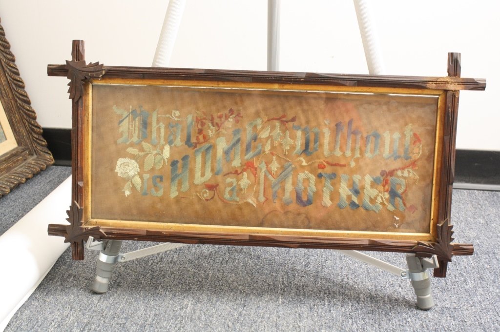 Needlepoint Framed What is Home without Mother: Needle point sign, professionally framed and matted, wood frame, one of the leaves on the frame is missing, measuring 26 inches wide by 14 inches tall Tramp art style Adirondack frame Decor