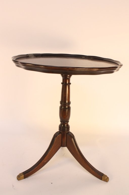 Mahogany pie table: Mahogany pedestal table with pie shaped table top rimmed measures 23.5 square by 27 Inches high. Rim has 5 inch chip. Three splayed legs to pedestal with brass tip details. Property of a Bronxville Es