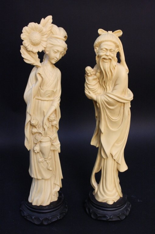 Pair of Carved Bone Asian Man and Woman Statutes: Standing on black stands. Marked with Asian letters beneath base. Woman Repaired around neck carrying a basket of roses and man carrying a baby. Measures 18 to 19 inches tall and base diameter measure