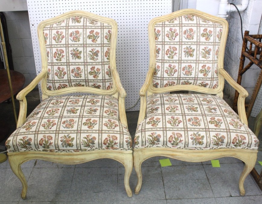 Pair of Country French Style Bergeres Chairs: Each hand painted wheat color, carved wood frame, upholstered back and seat, upholstery in excellent condition, each measures 40 inches tall by 28 inches wide by 25 inches deep