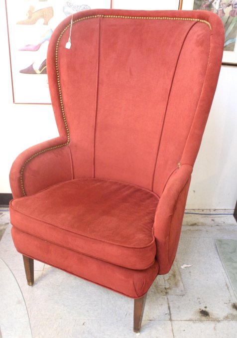 Red Swayed Open Back Wing Chair: Claret colored swayed slim profile wing chair, rounded arms and back, piping detail, brass nail head trim, loose seat cushion tight back, measures 47 inches tall by 30 inches wide by 21 inches deep