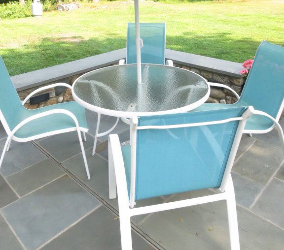 Outdoor Dining Table and Chairs: Aluminum and glass round table includes base only for an umbrella (no umbrella) and four chairs.