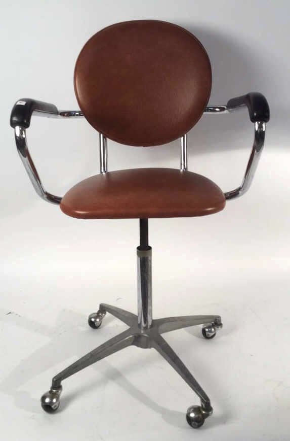 Vintage BRANDT INDUSTRIES INC Swivel Chair: Vintage BRANDT INDUSTRIES INC Swivel Chair, with original do not remove tag, chair has two arms with black covers, burnt orang seat cushion and back rest, metal base with four wheels, measuring in inc